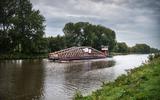 Duwsleepboot Rodie 2 met het 42 meter lange houten brugdeel van de Blauwe Loper. 