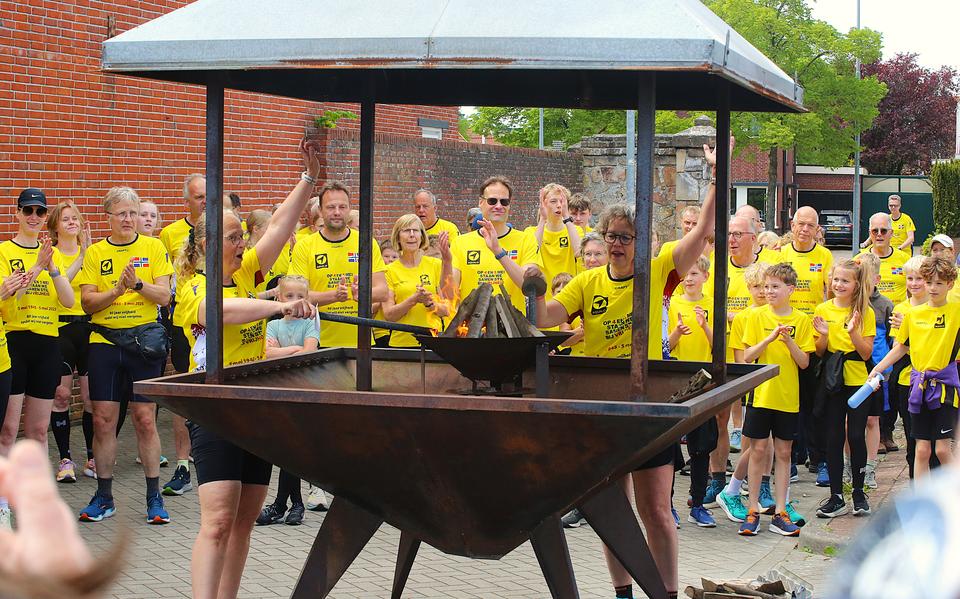 Het bevrijdingsvuur, dat door lopers van atletiekvereniging Aquilo uit Wageningen is gehaald, wordt ontstoken.