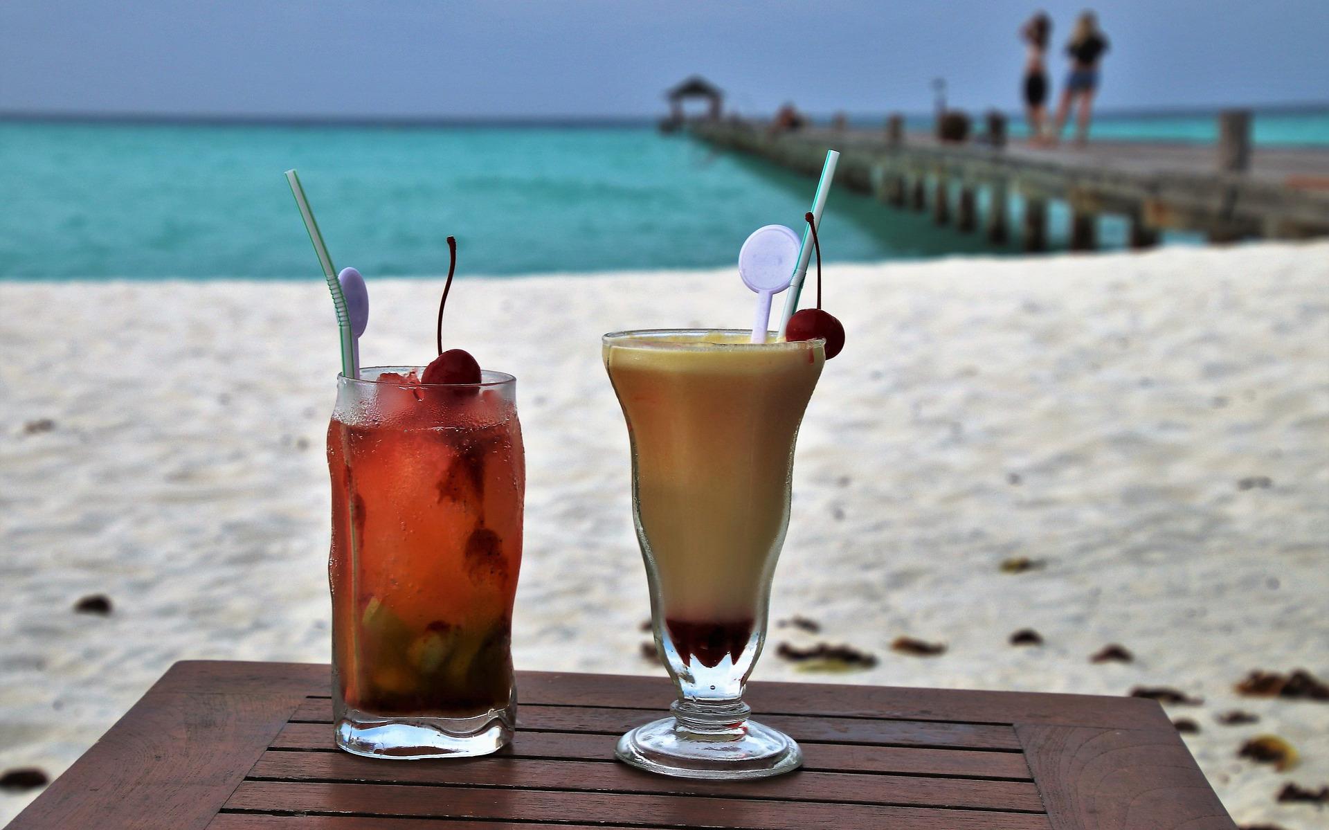 Aan het strand met een cocktail.