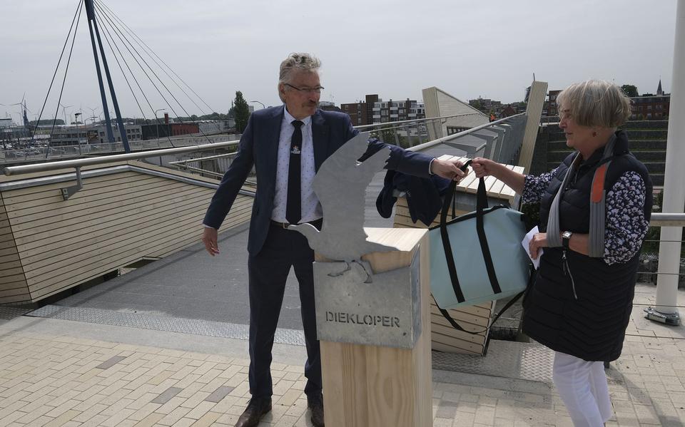 Wethouder Jan Menninga overhandigt Janny Volmer als cadeau (voor het bedenken van de naam ‘Diekloper’) een koeltas. De onthulling van de naam voor de nieuwe brug is tevens de afronding van het grote project Marconi Buitendijks.
