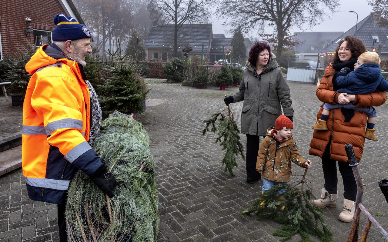 Jan van Wijk met een ingepakte kerstboom voor Trijnie Bogaard en haar dochter Carlien uit Roden.