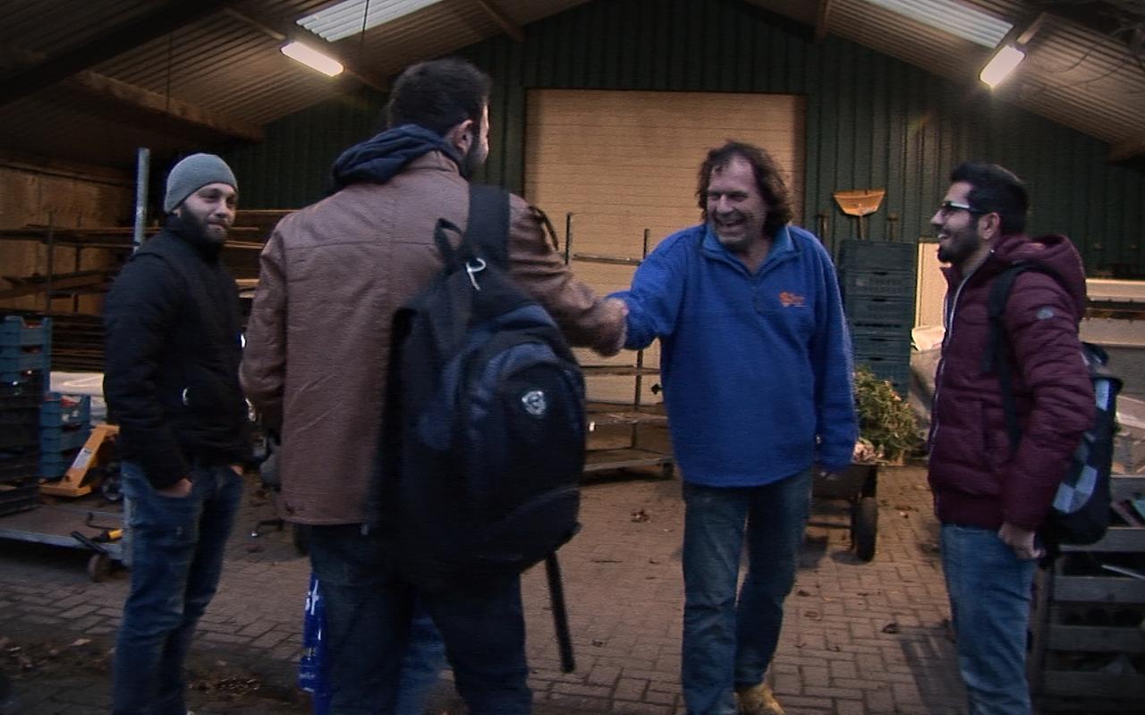 Jan Voortman (blauwe jas) ontvangt voormalige asielzoekers. Still uit de film Oranje, Waar een klein dorp groot in kan zijn.