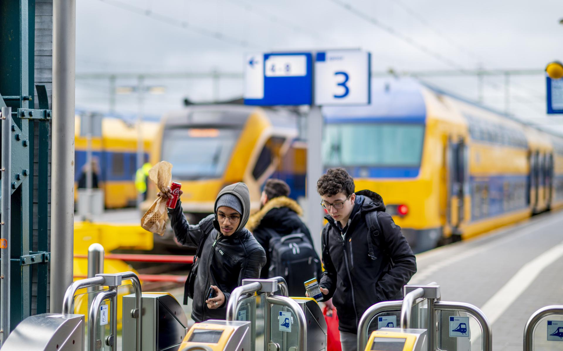 Treinreizigers checken in op station Leeuwarden.