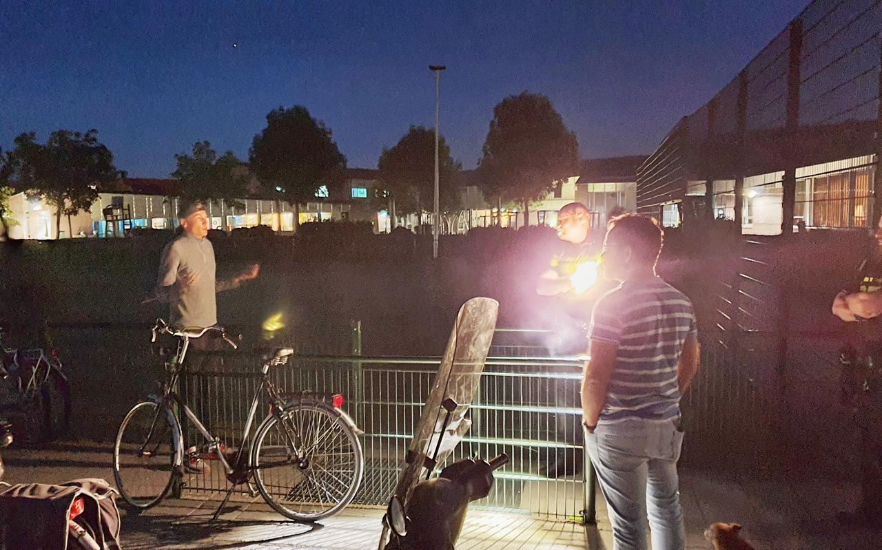De politie in gesprek met rondhangende jeugd op een voetbalveldje in Kloosterveen. Gilles Dikkerboom (links) legt de situatie aan de politie uit. Foto: DVHN