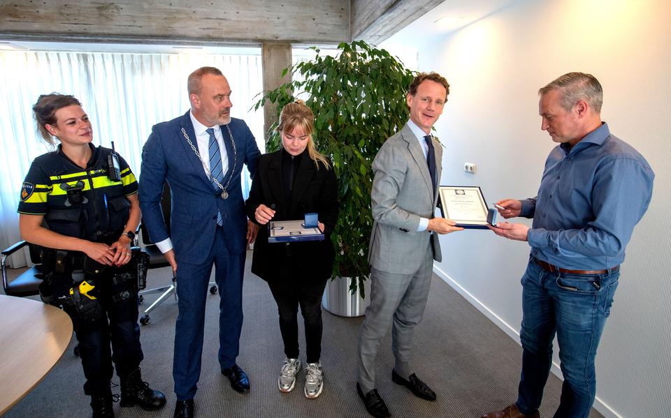 Lilian Mulder (m) en Milan Orsel (r) ontvangen een oorkonde en medaille van de Koninklijke Maatschappij tot Redding van Drenkelingen. Ze haalden in november een scootmobielster uit het steenkoude Stadskanaal in Musselkanaal. 