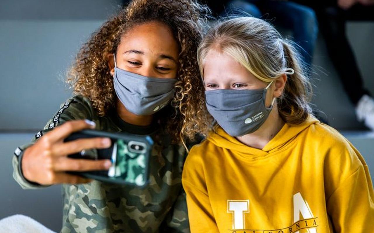 Leerlingen van een middelbare school maken een selfie met hun mondkapje tijdens de pauze. Leerlingen van een middelbare school maken een selfie met hun mondkapje tijdens de pauze.