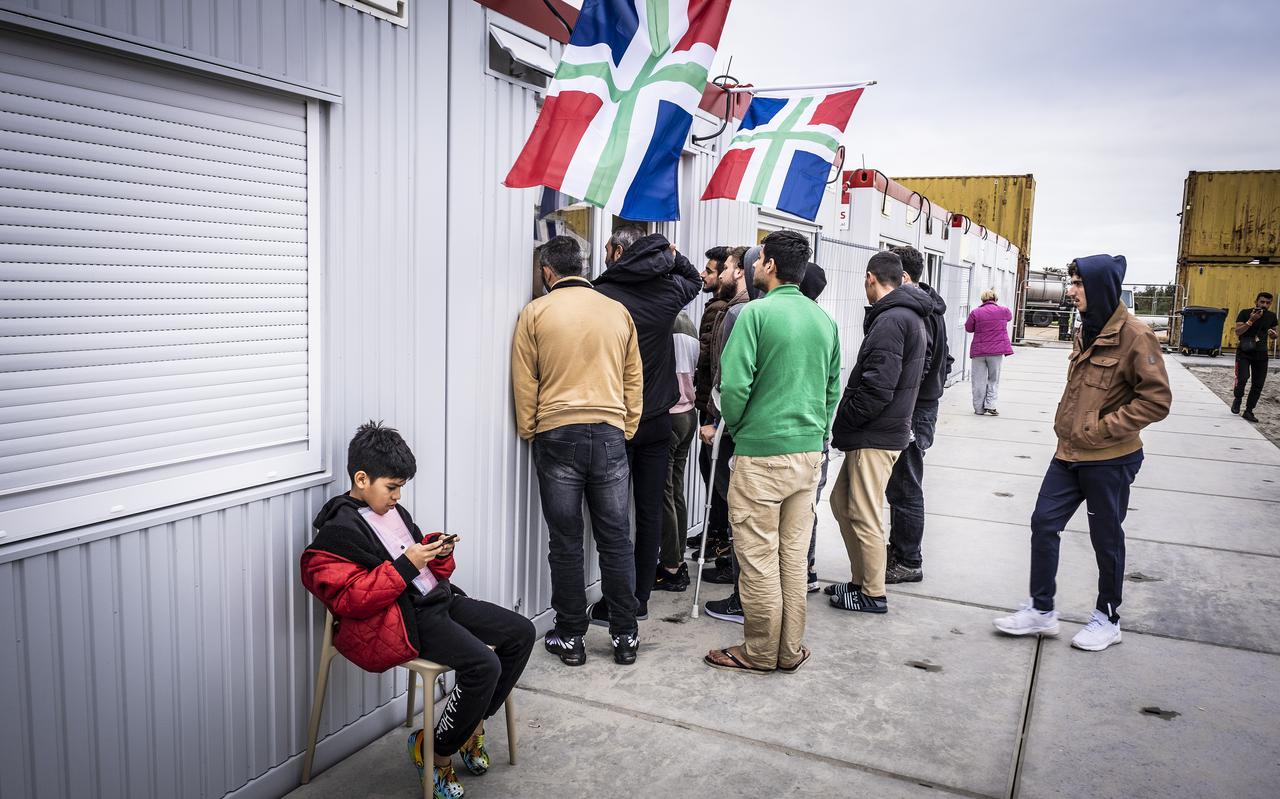 Asielzoekers bij het winkeltje op het terrein van het COA. 