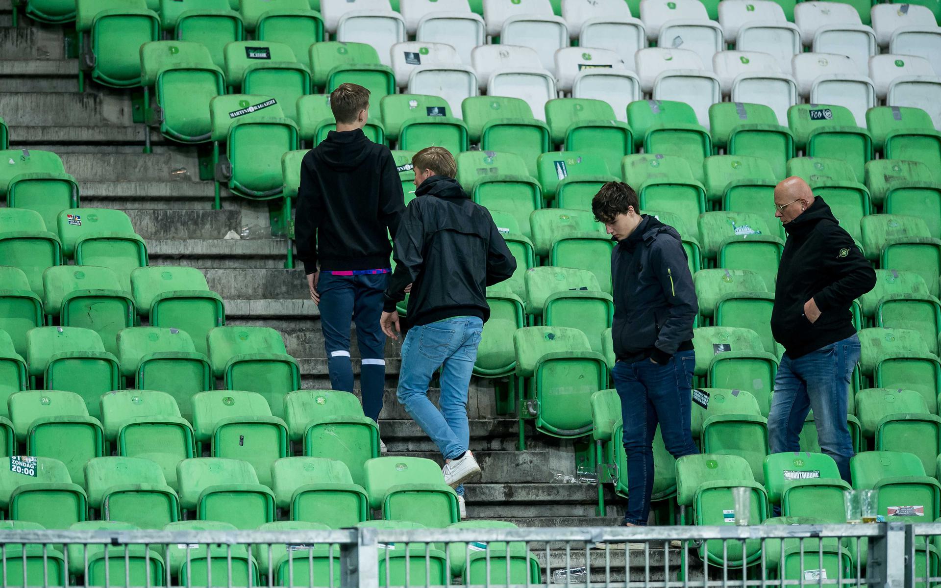 De laatste supporters verlaten gedesillusioneerd het stadion van FC Groningen nadat de wedstrijd tegen NEC is gestaakt.