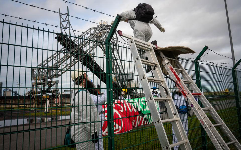 Activisten van Extinction Rebellion klimmen over het hek van de kolencentrale van RWE.