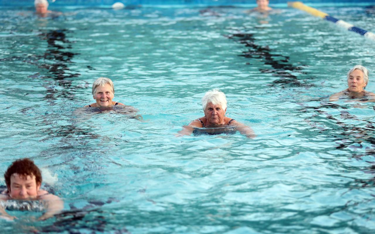 Zwemmers genieten van het met zonne-energie verwarmde water in De Leemdobben in Vries.