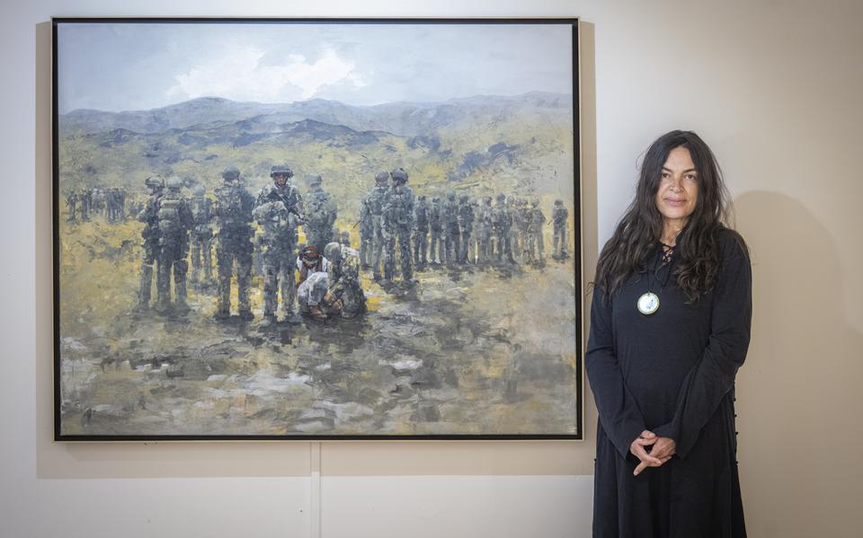 Kunstenares Roxanne Monsanto bij haar schilderij over de aanhouding van Talibanstrijders na de dood van Marc Harders en Jeroen Houweling.
