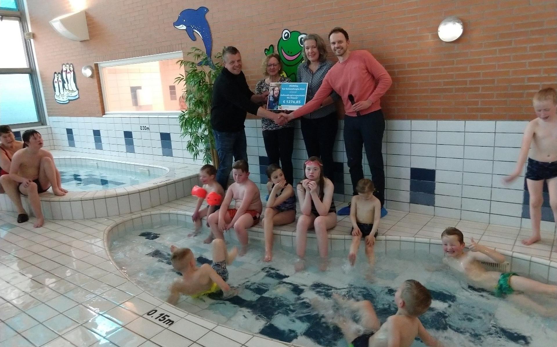 Tijdens het wekelijkse zwemlesuurtje werd aan voorzitter Koos in ’t Hout van G.S.C. de Stroom de cheque uitgereikt.
