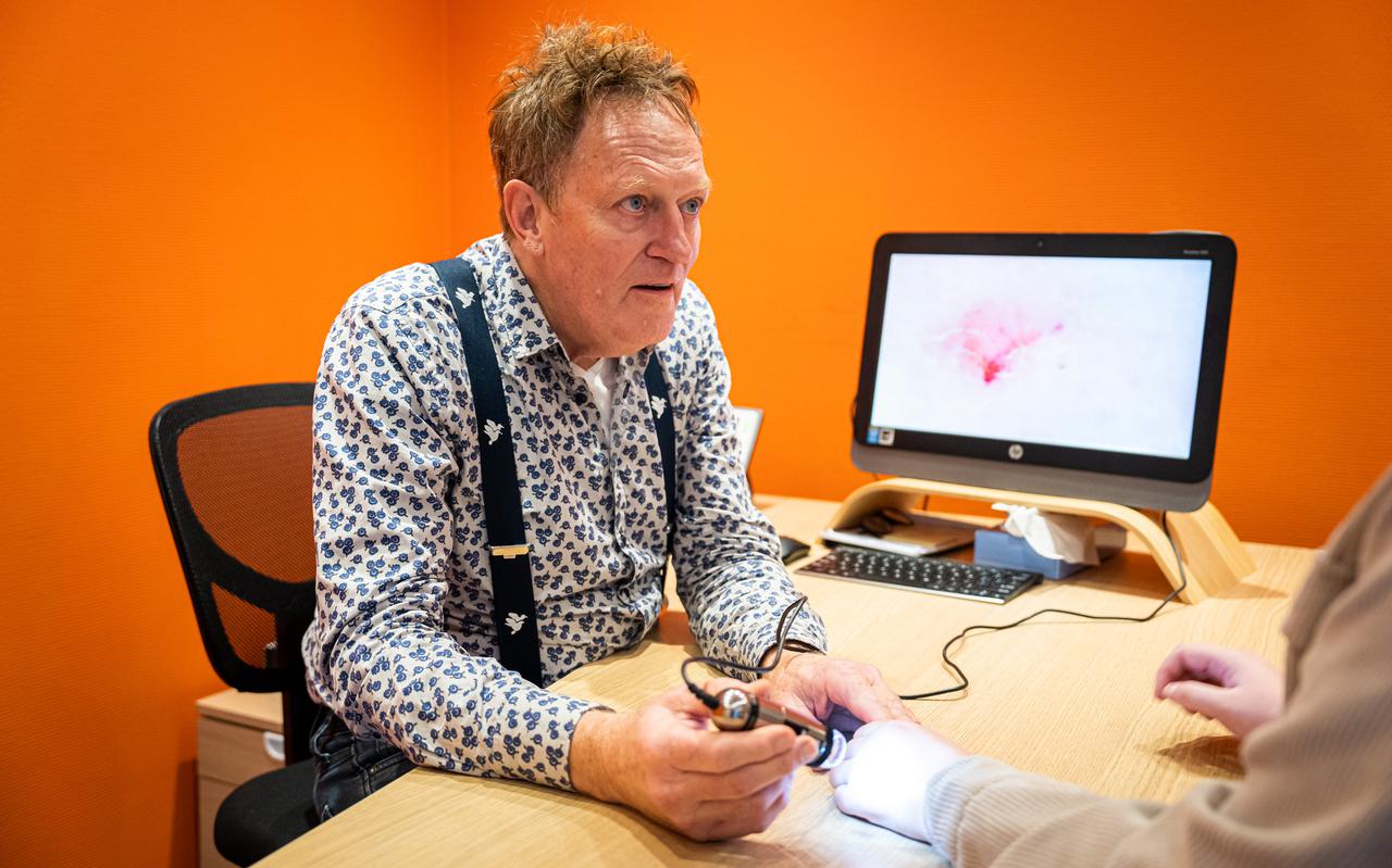 Huisarts Maarten Goedhart op zoek naar de schurftmijt in de huid van een patiënt.