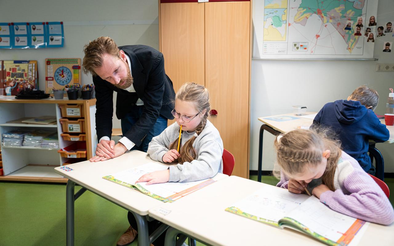 Onderwijsminister Dennis Wiersma kijkt over de schouder van Solomiia mee naar hoe zij tobt over de rekensommen in haar boek. Klasgenootje Katya (r) is voortvarend sommen aan het invullen. Onderwijsminister Dennis Wiersma kijkt over de schouder van Solomiia mee naar hoe zij tobt over de rekensommen in haar boek. Klasgenootje Katya (r) is voortvarend sommen aan het invullen.