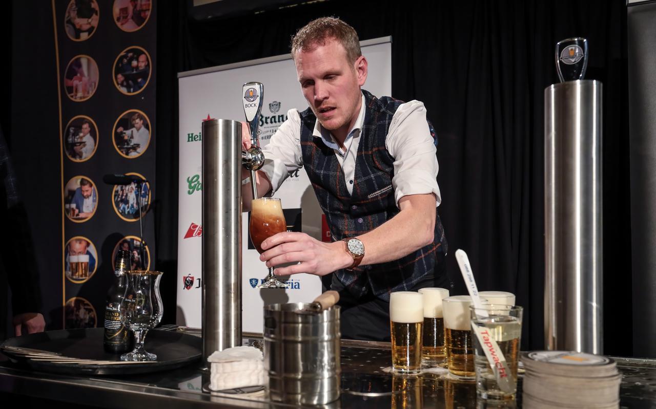 Nico van der Veen uit Westerbork tapt een biertje tijdens het NK Biertappen in Amsterdam.