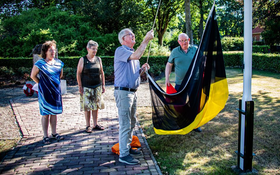 Wubbe Kuper (rechts) en Egbert Jans hangen de Belgische vlag halfstok, Meike (links) en Fenna Stedema kijken toe