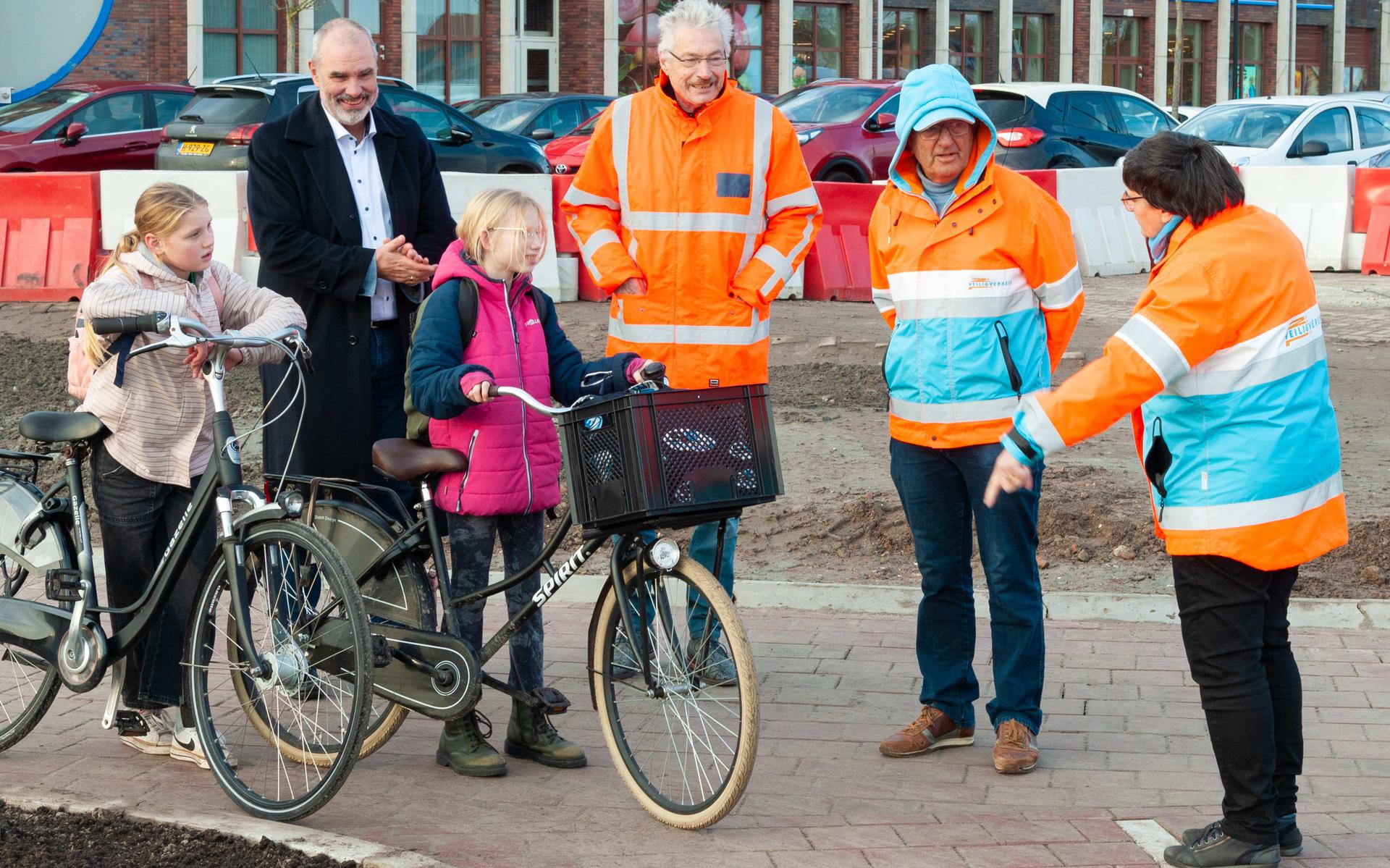 De wethouders Jan Menninga en Hans Ronde helpen samen met Veilig Verkeer Nederland leerlingen bij het oversteken op de nieuwe rotonde in Appingedam. Eigen foto