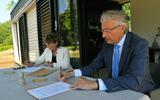 Directeur Hilde van Ree (links) en wethouder Jan Menninga (rechts) ondertekenen de koopovereenkomst voor enkele stukken grond op het Groot Bronswijk-terrein in Wagenborgen.