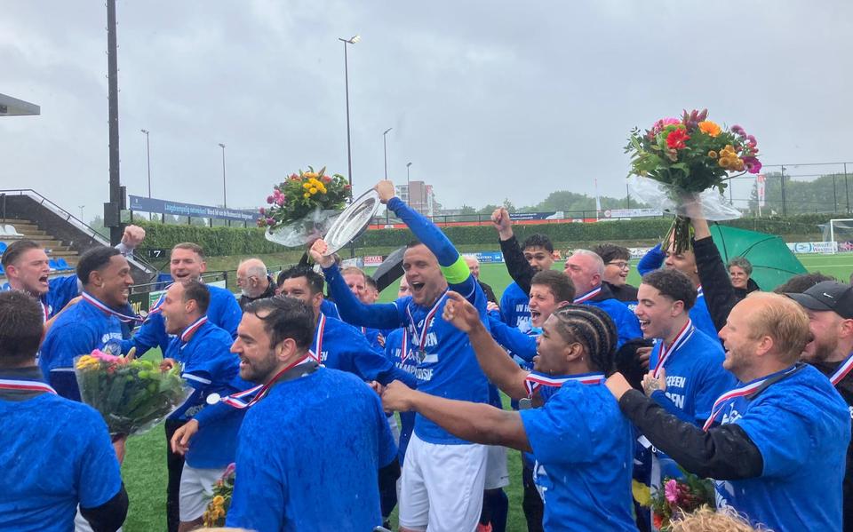 Aanvoerder Levon van Dijk viert feest met kampioensschaal, de selectie viert mee.