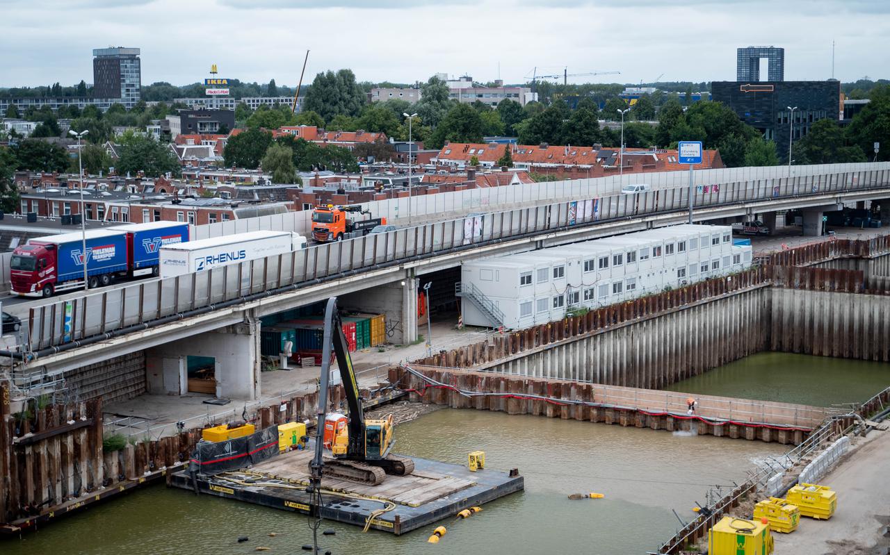 De bouw van de ringwegtunnel in volle gang, bij de woonwijken Oosterpoort en De Linie. Rechts: het eerste bouwvak waar vrijwel alle water uit weggepompt is. 