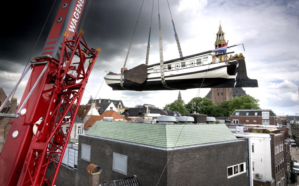 Het vrachtschip Alida hangt in de lucht voor de verhuizing naar het Kunstmuseum De Ploeg.