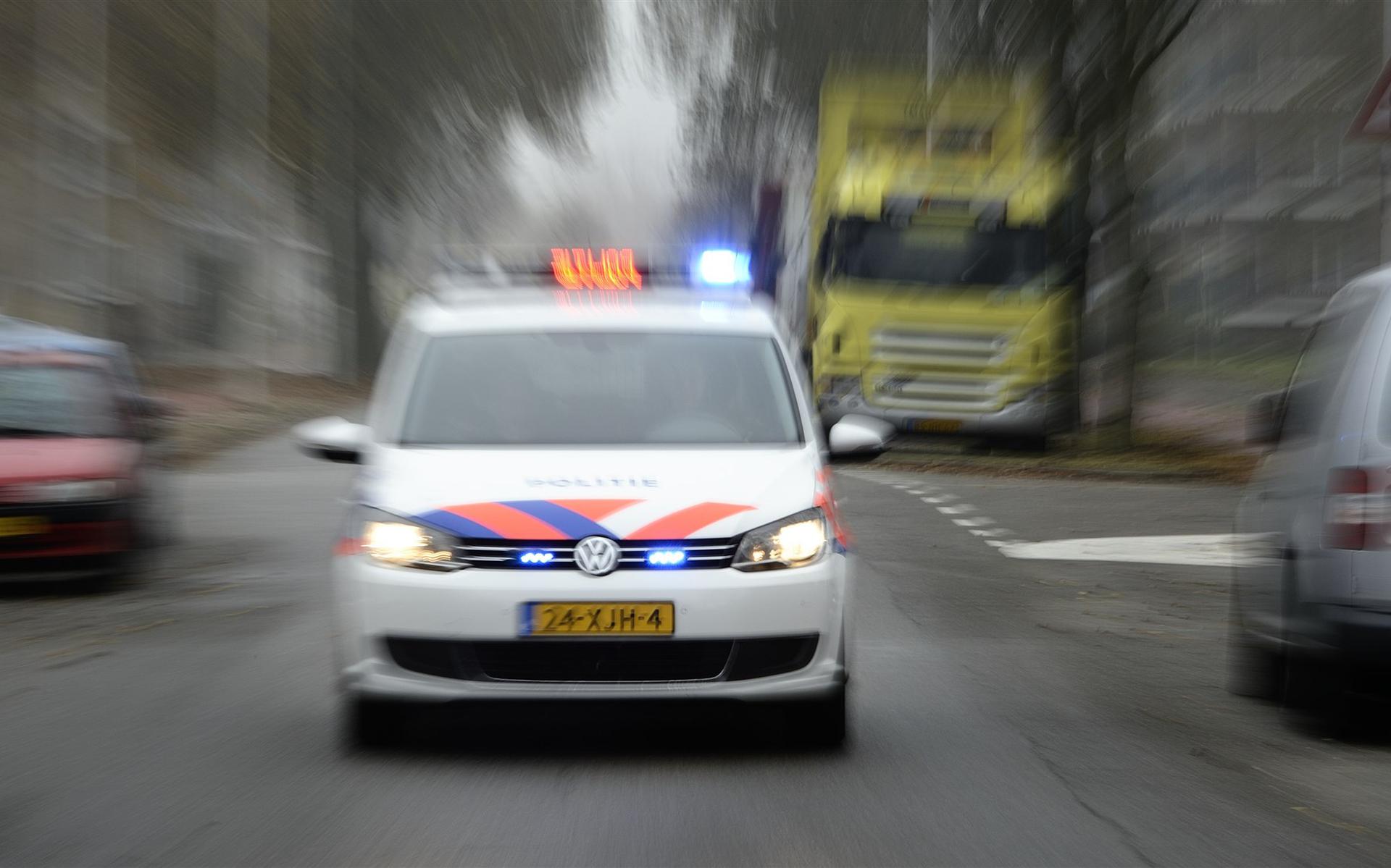 Een politieauto onderweg met sirene en zwaailicht. 
