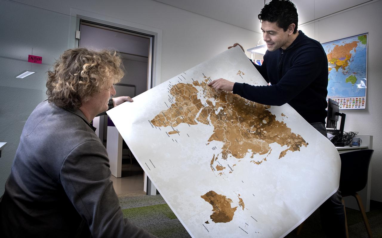 Michiel Kasteleijn (links) en Niek Huizenga buigen zich over de wereldkaart. Alle continenten zijn momenteel als startups vertegenwoordigd in Groningen. 