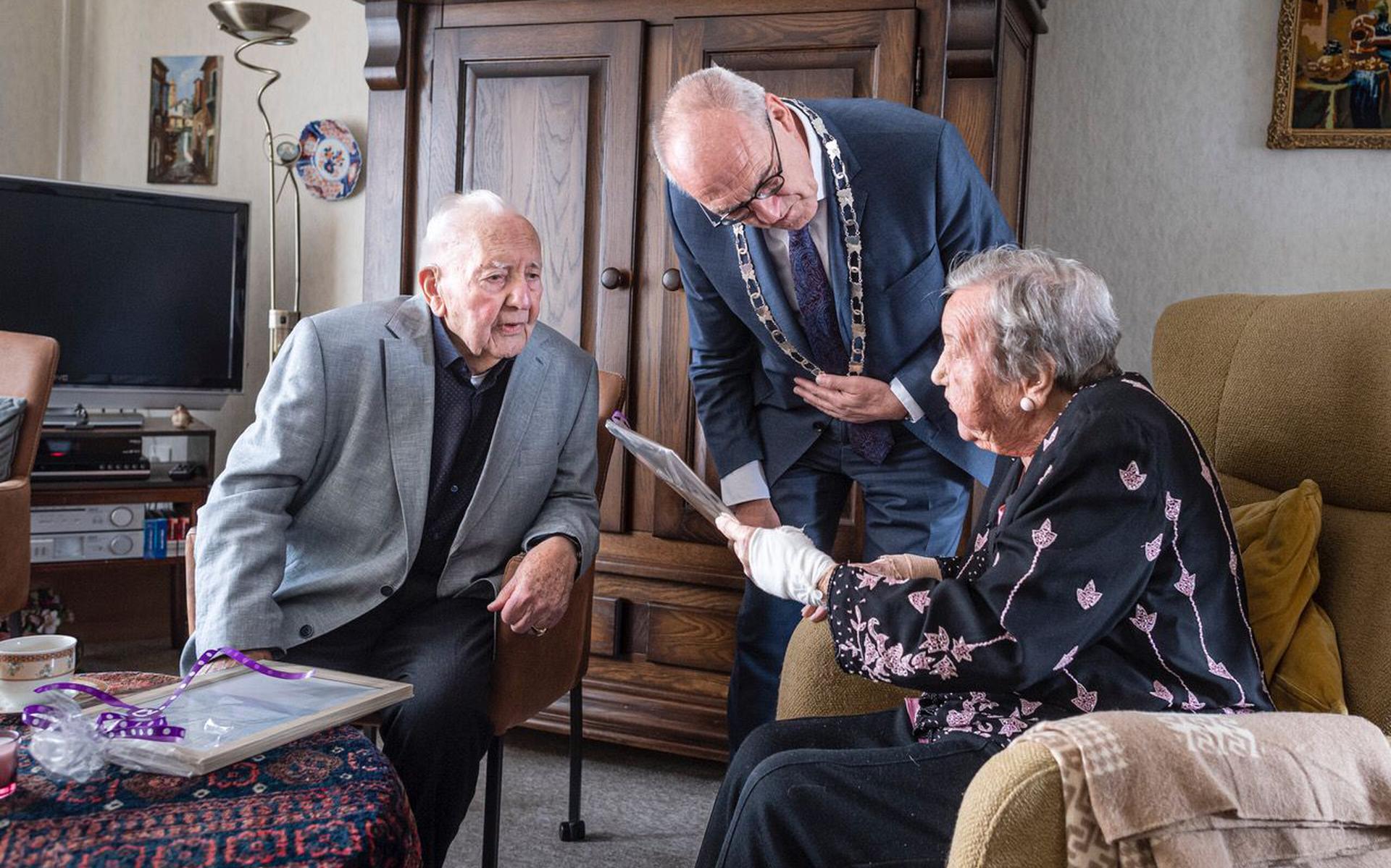Albertus Bosscha (100) en Harmanna Bosscha-Auwema (98), ook nog eens net 77 jaar getrouwd, met de felicitaties en cadeaus van burgemeester Adriaan Hoogendoorn van Midden-Groningen.
