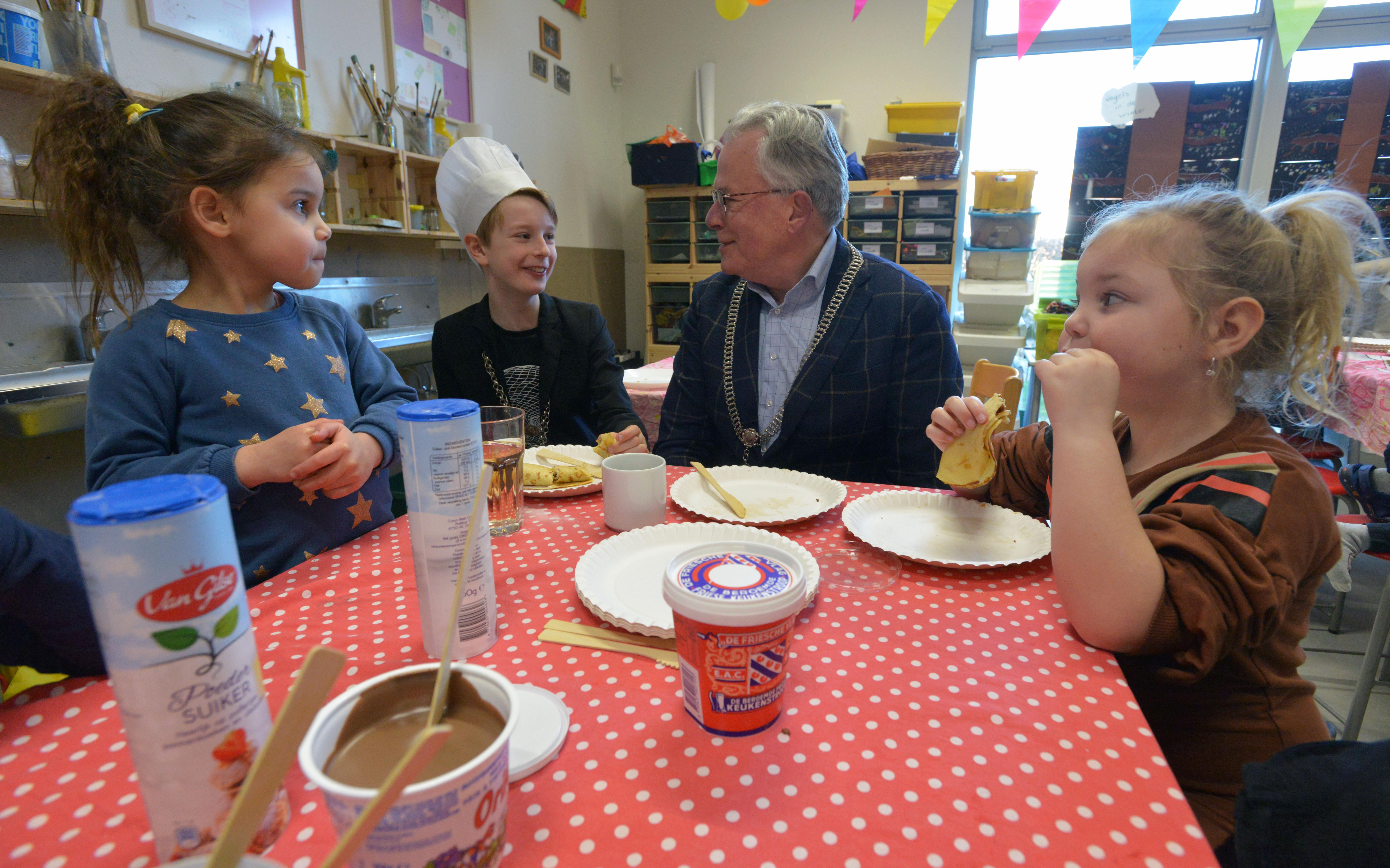 Burgemeesters smullen mee tijdens pannenkoekendag op OBS de Huifkar in Ten Boer. 'Kinderburgemeester