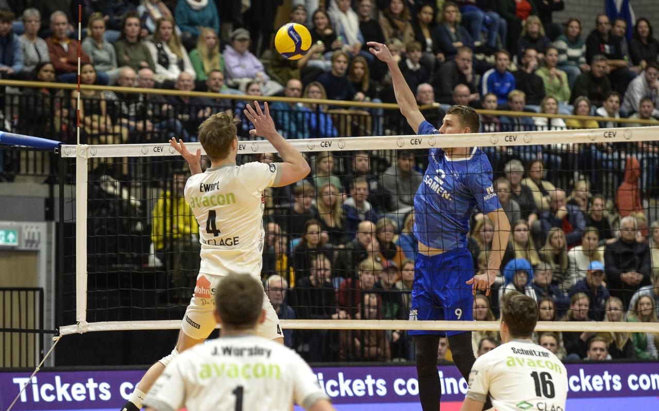 Lycurgus-speler Ryan Coenen tikt voor de volle tribunes de bal over het blok van SVG Luneburg-speler Jordan Ewert. Lycurgus-speler Ryan Coenen tikt voor de volle tribunes de bal over het blok van SVG Luneburg-speler Jordan Ewert.