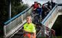 Stewards manen fietsers de veiligheid in acht te nemen als ze over de Gerrit Krolbrug gaan. 