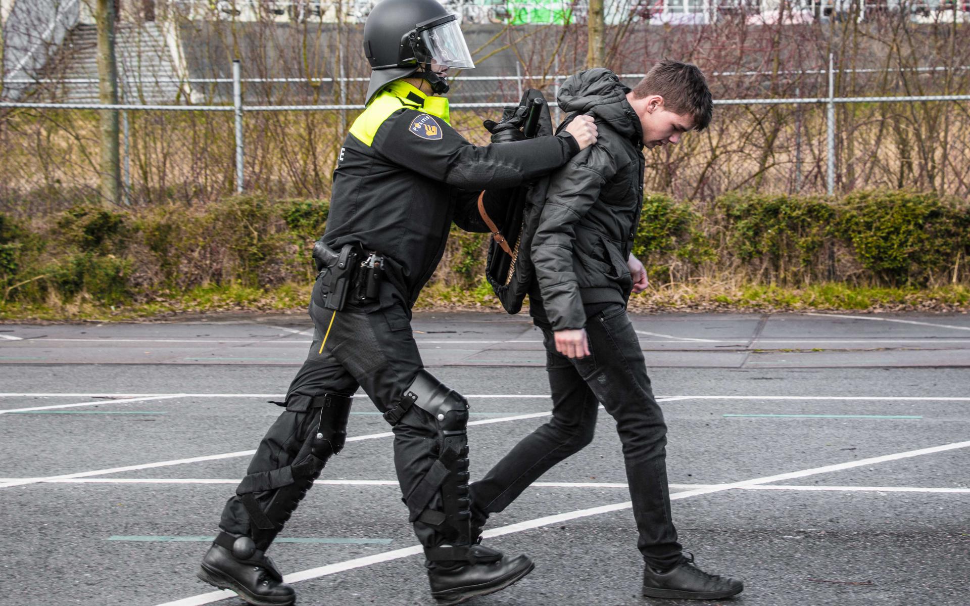 Een "demonstrant" wordt weggebracht door de ME. Foto Matthijs Sorgdrager