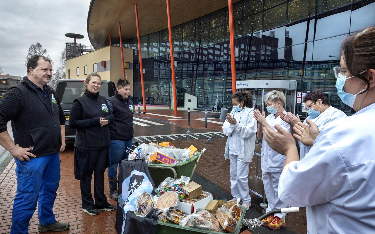Vertegenwoordigers van het Boeren Samenwerkingsverband Noord Nederland brengen twee kruiwagens vol met gedoneerde levensmiddelen naar het UMCG. Ze zitten vol cadeaus voor het UMCG-personeel.