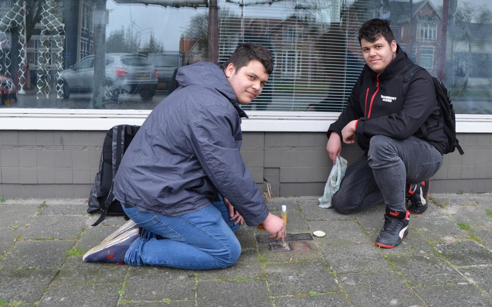 Mitchell en Nick van Reede uit Ter Apel maken de Stolpersteine voor de woning aan de Handelsstraat 43 in Stadskanaal schoon.