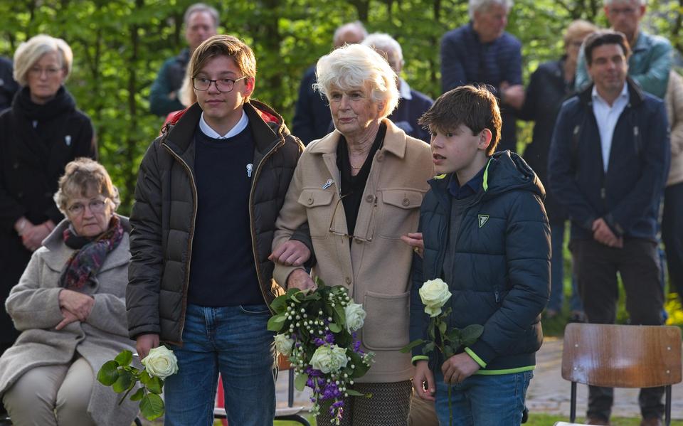Cécile Nieuwenhuijsen-de Kock legt met twee kleinkinderen bloemen op het graf van haar vader.
