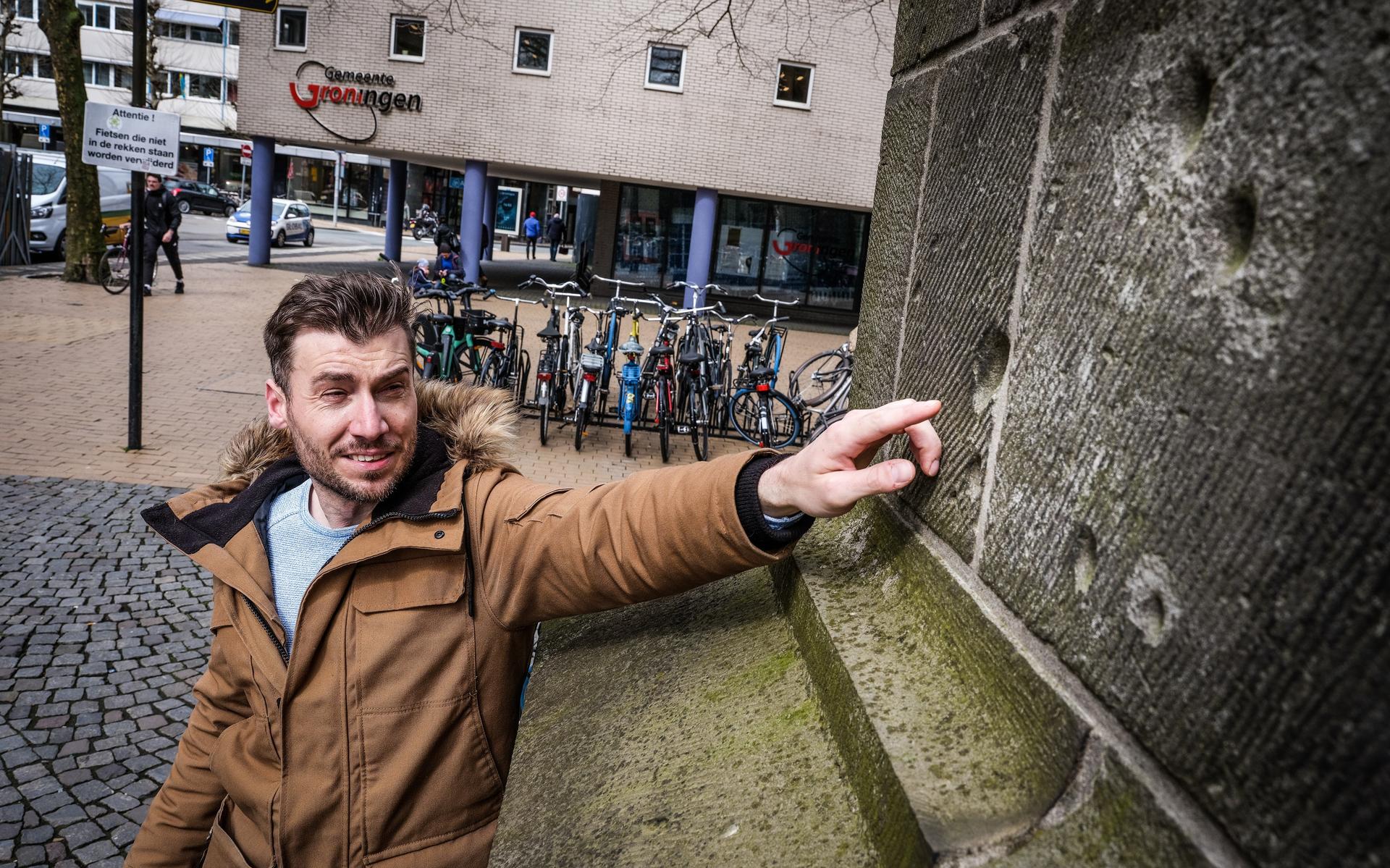 WOII-gids Joël Stoppels wijst de kogelgaten in de muren van de Martinitoren aan.
