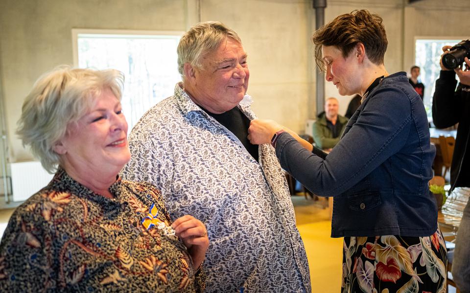 Loco-burgemeester Kirsten Ipema speldt Joop Steijvers de onderscheiding op. Zijn vrouw Christel toont trots haar lintje.