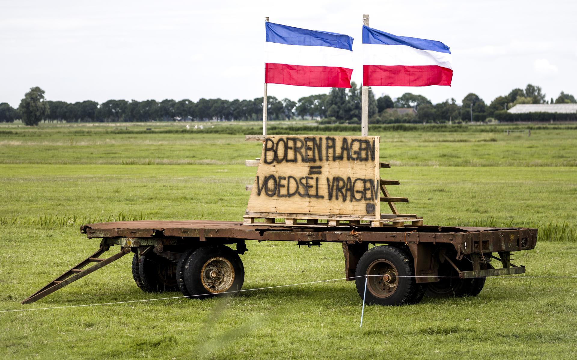 Een protestbord in een weiland met daarboven omgekeerde Nederlandse vlaggen. Boeren protesteren op deze manier tegen de stikstofmaatregelen van het kabinet. Nabestaanden van omgekomen militairen willen dat de vlaggen voor 4 en 5 mei worden weggehaald.