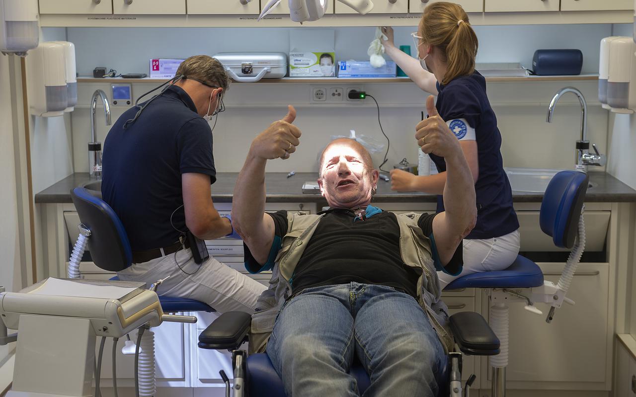 Marcel Hullegie wordt geholpen in de tandartsbus. 