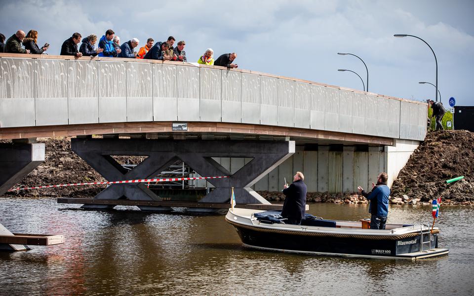 na het seintje van gedeputeerde Tjeerd van Dekken, staande op de brug (derde van rechts), mag wethouder Erich Wünker van Oldambt (in het bootje) het lint doorknippen. De Beekjuffer is daarmee officieel in gebruik genomen.  