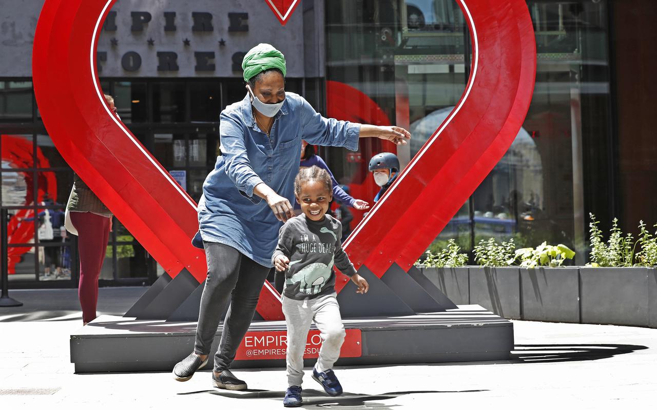 Moeder Kasi Addison rent achter haar 2-jarig zoontje Micah Addison aan op een speelplek in Brooklyn Bridge Park. 