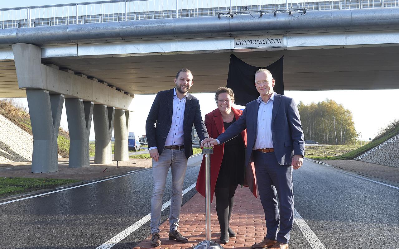Met een druk op de knop onthullen wethouder René van der Weide (links), gedeputeerde Nelleke Vedelaar en directeur Roel van de Berg van wegenbouwer KWS Zwolle-Leek de naam.