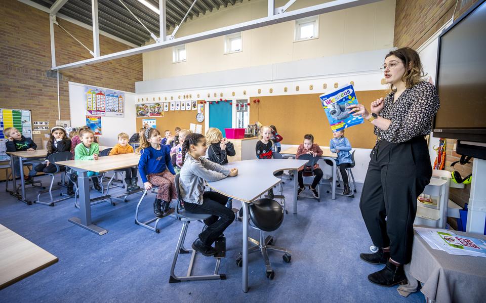Amber Tieck leest in het Drents voor aan leerlingen  van groep 3 van de Theo Thijssenschool in Assen.