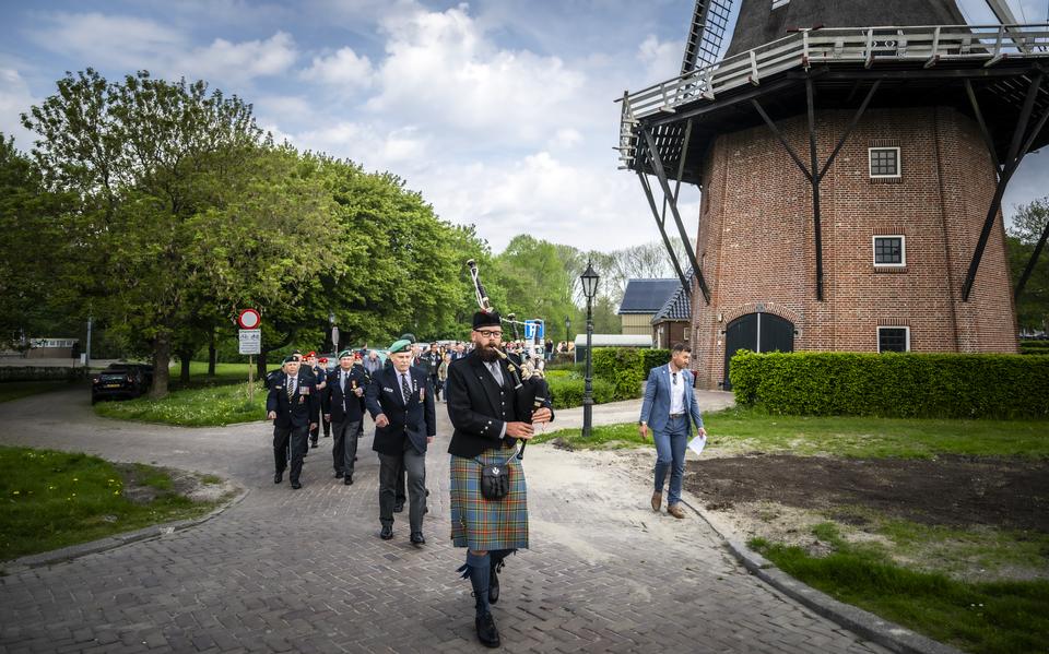 Doedelzakspeler Martijn Bakker begeleidt een stoet Canadese soldaten richting het oorlogsmonument in Farmsum.