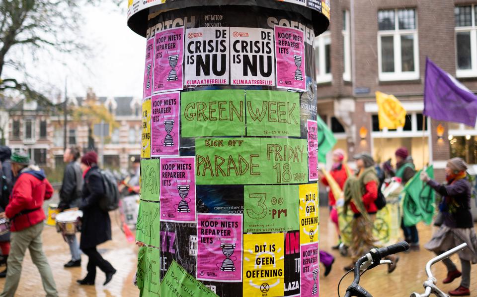 Extinction Rebellion Groningen protesteert tegen Black Friday met een parade en aanplakbiljetten.