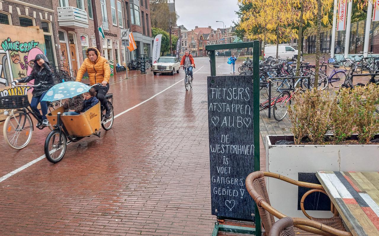 Naast verkeersborden die aangeven dat de Westerkade voetgangersgebied is, proberen ondernemers de mensen hier zelf ook op te attenderen. Het effect is vooralsnog teleurstellend. 