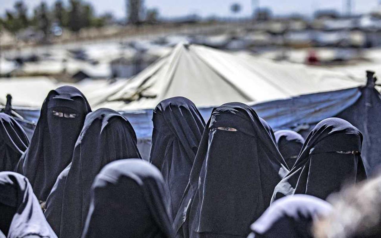 Vrouwen van IS-strijders, onherkenbaar onder hun boerka’s, in een kamp het noorden van Syrië.