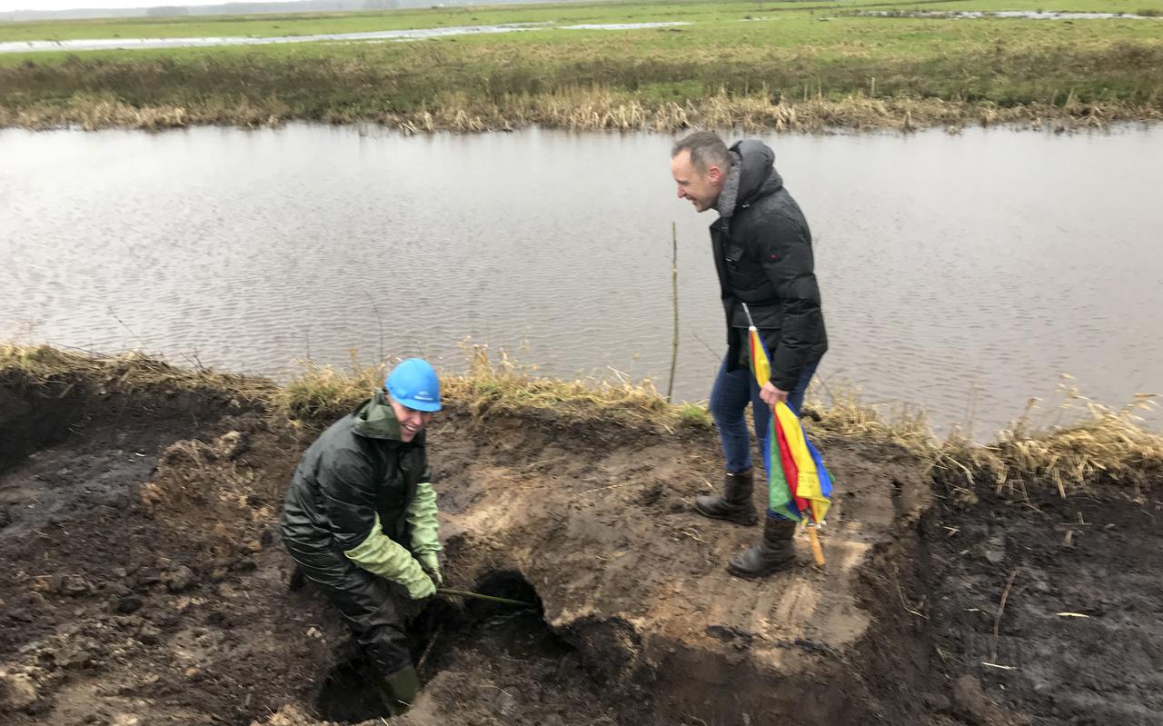 Medewerkers van waterschap Hunze en Aa's inspecteren een beverhol in een dijk.