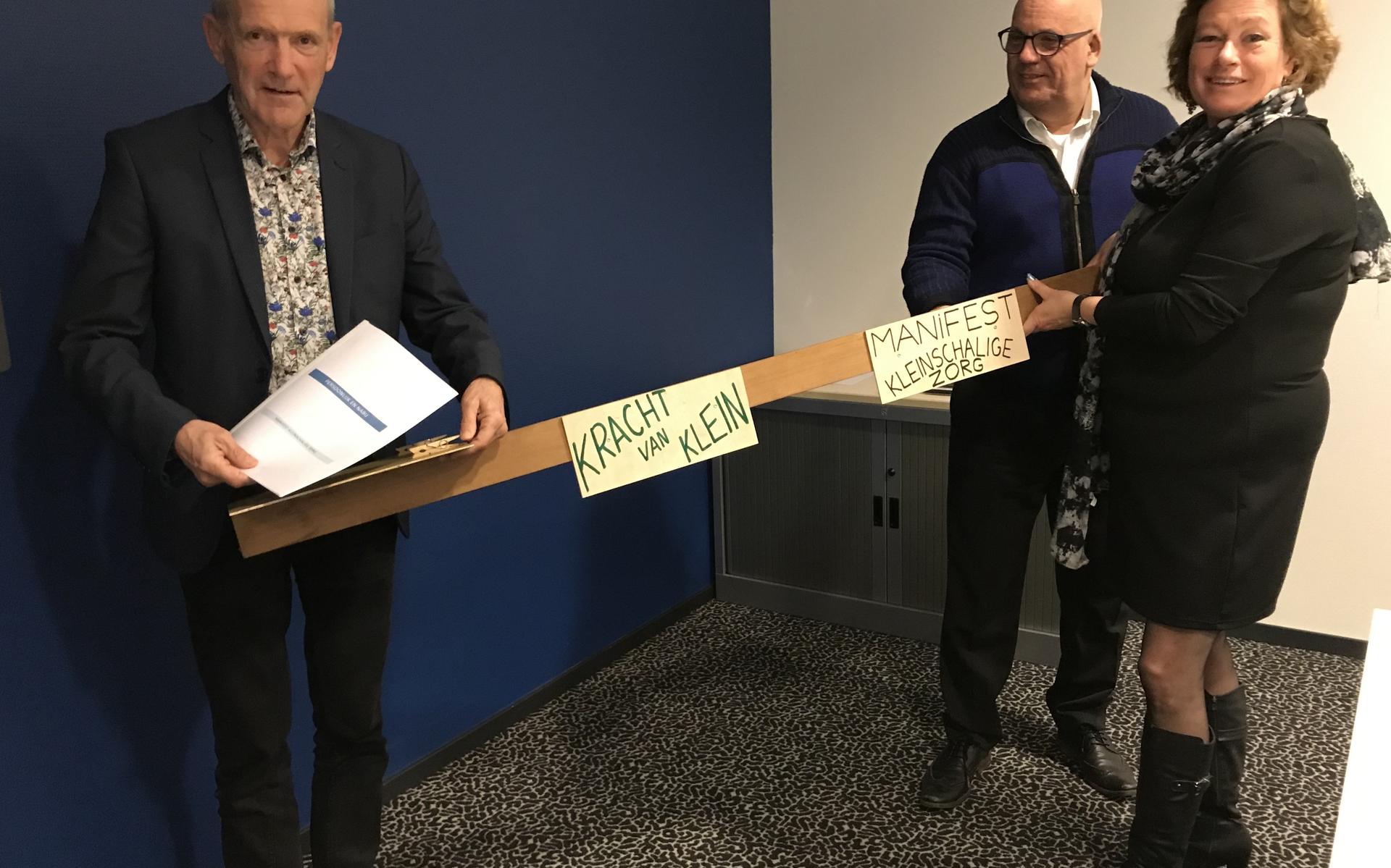 Wethouder Peter Verschuren (links) neemt het Manifest Kleinschalige Zorg coronaproof in ontvangst van Andrea Lagro en Reg Mulder