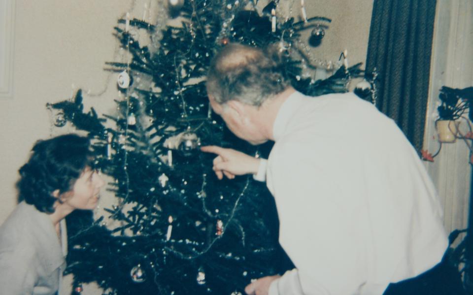 De vader en moeder van Geert Meertens bewonderen de fraai versierde kerstboom.